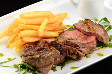 grilled steak with french fries and vegetables