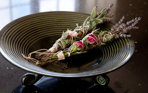 Sage, rose and lavender smudge sticks in burning bowl