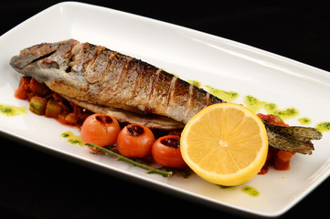 fish with lemon and vegetables on a plate