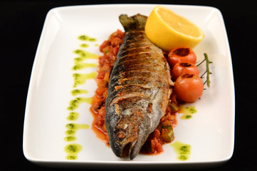grilled fish with vegetables on white plate