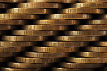 A wall of stacks of coins. Dark wallpaper. Macro
