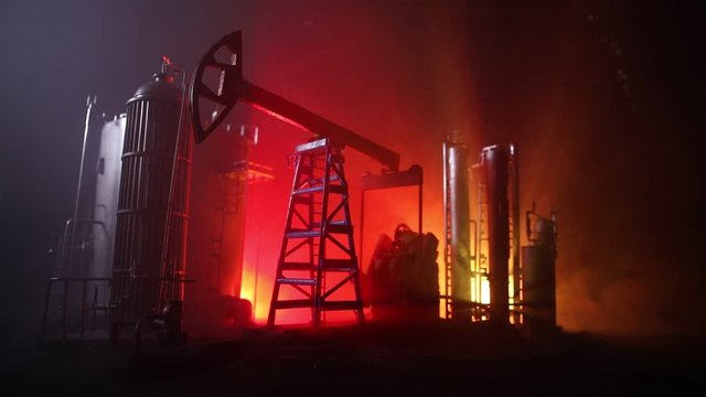 Oil pump and oil refining factory at night with fog and backlight. Energy industrial concept. Selective focus. Artwork decoration.