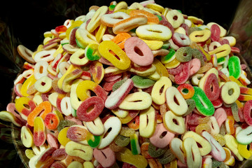 A bunch of colorful marmalade candies in the form of a ring (bagel), sprinkled with sugar or citric...