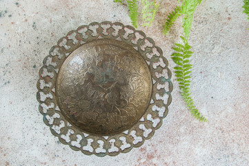 Old brass bowl and green plant