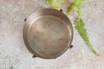 Old metal bowl on a concrete background.