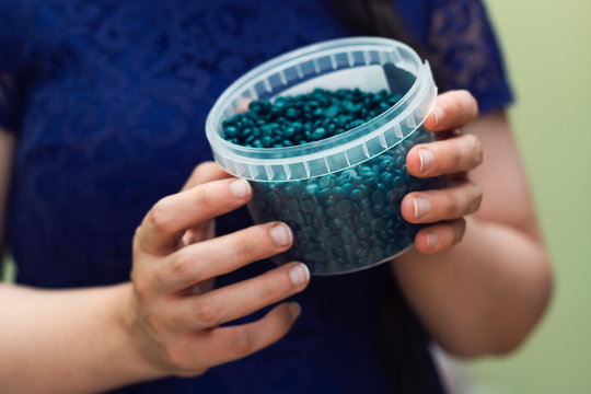 closeup woman had holding depilatory pearl hard wax beans box