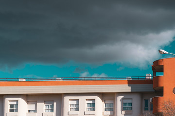 Orange and white building in contrast to stormy blue sky.