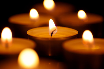 Burning candles shot with shallow depth of field on black background