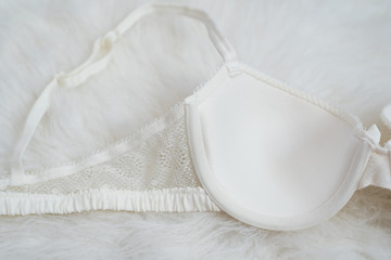 Part white bodice with lace on white fur. Inner side. Underwear, fashion concept. Close up