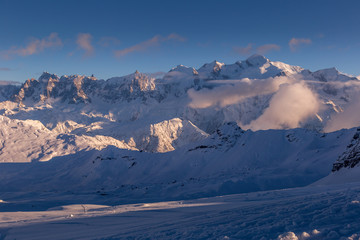 The setting sun illuminates the alpine panorama