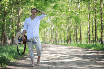 A man with a guitar on summer day outdoors