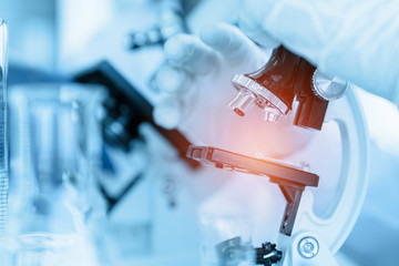 Healthcare and medicine concept, Close Up Scientist using microscope in laboratory room while making medical testing and research