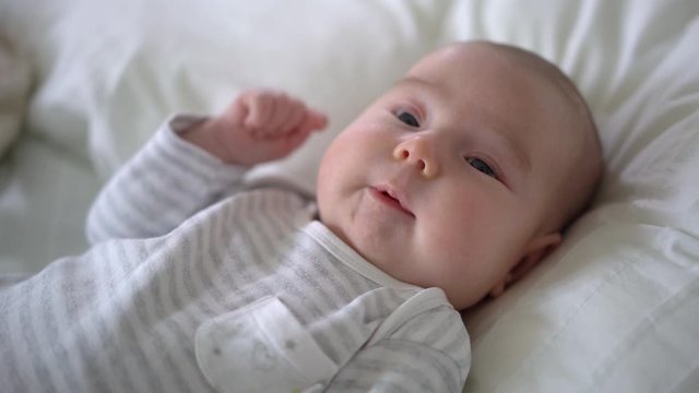 close-up portrait of cute cheerful smiling little newborn caucasian baby girl 