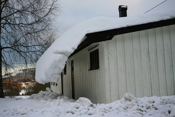 Thick snow hanging on the roof.