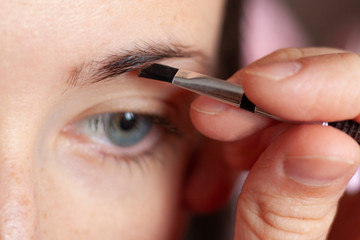She is doing eyebrows makeup