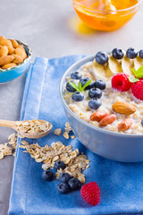 Healthy homemade oatmeal with berries and nuts for breakfast. Oatmeal with fruits, nuts and honey. Oatmeal with blueberries, banana and raspberries