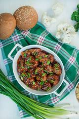 Fried Cauliflower in Sauce and Sesame. Asian style dish. White wood background. Space for text. Flat lay.