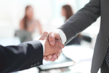 reliable handshake of business partners in the office