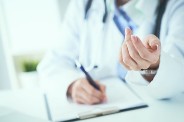 Female doctor explaining patient symptoms or asking a question as they discuss together in a consultation. Doctor held out his hand to the patient close-up.