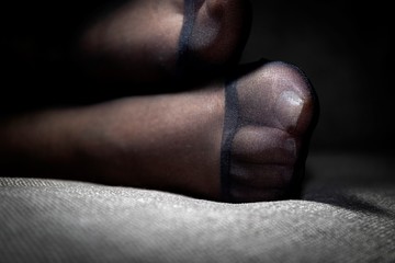 A close up potrait of a girls pantyhose feet and the reinforced toe on a couch indoor.