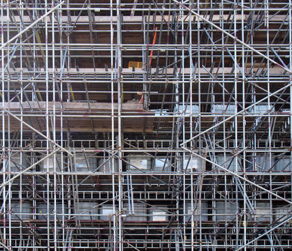 a full frame image of a network of scaffolding covering a large building under renovation