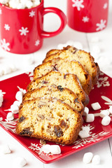 Red mugs with hot chocolate and marshmallows and  Christmas cake portion
