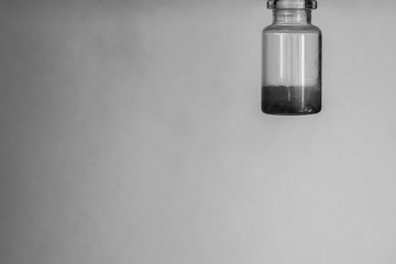 Minimalism. The inverted bottle hangs from the top right. The bottle is half full. Black-white...