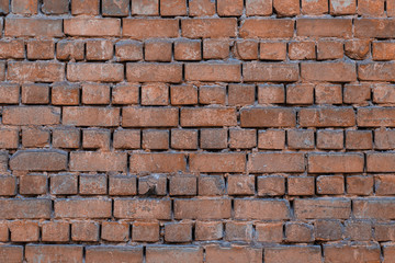 Texture of brick wall with peeling orange-and-gray paint