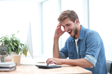 happy business man looking at his calculator