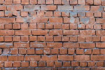 Texture of brick wall with peeling orange-and-gray paint