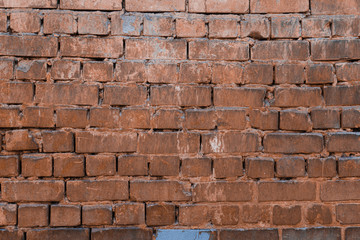 Texture of brick wall with peeling orange-and-gray paint