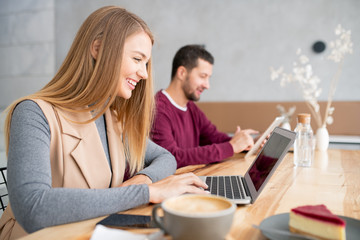 Cheerful girl looking at her friend while communicating through video-chat