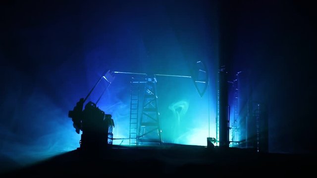 Oil pump and oil refining factory at night with fog and backlight. Energy industrial concept. Selective focus. Artwork decoration.