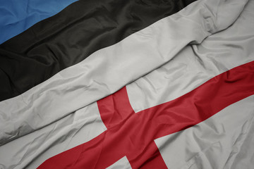 waving colorful flag of england and national flag of estonia.