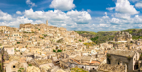 Fototapeta na wymiar Aerial panoramic view of historical centre Sasso Caveoso of old ancient town Sassi di Matera with rock cave houses, blue sky white clouds, UNESCO World Heritage Site, Basilicata, Southern Italy