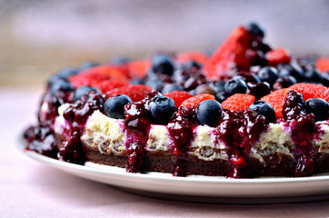 Cheesecake tart with fresh strawberries, blueberries and cherry jam.