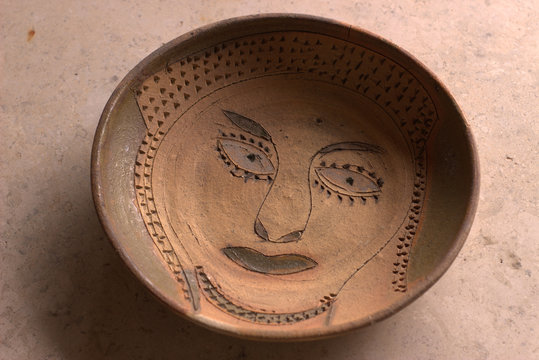 Clay bowl with primitive face design