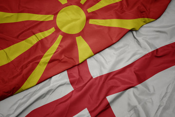 waving colorful flag of england and national flag of macedonia.