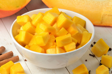 Bowl of chopped pumpkin, cloves and cinnamon prepared for fruit stew.