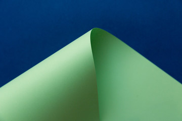 Abstract creatively formed neo mint color paper on dark navy blue background