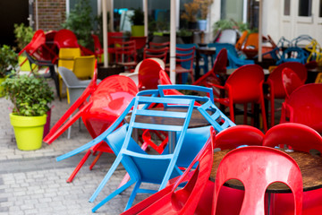 Colourful tables and chairs in a cafe. Yellow, blue, red colors. Outdoor European restaurant in the city