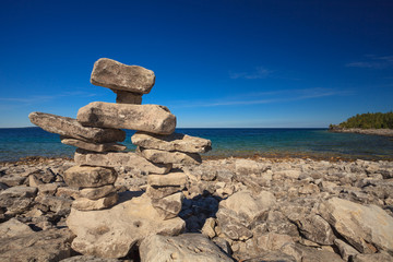 Inukshuk or Inuksuk Landmark At The Rocky Beach On Huron Lake