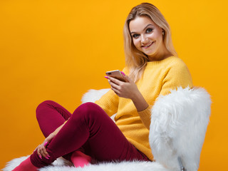Happy and cheerful blonde uses a smartphone to communicate on social networks