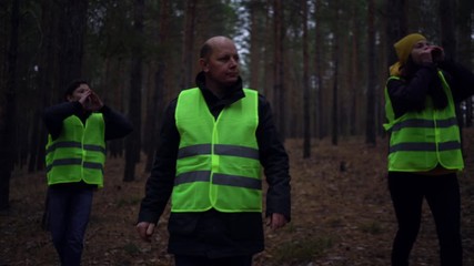 group of volunteers in green vests went in search of missing persons in a pine forest