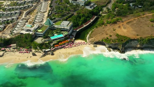 Tourists relaxing and surfing, umbrellas and deck chairs on the beach in Asia. Aerial view. Shot in 4K on Hasselblad, H.265