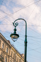 Fototapeta na wymiar Street lamp, wires, street sign against blue sky