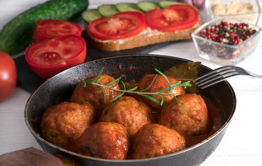 .cutlets in a pan on a white wooden background