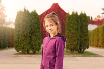 Fototapeta premium Outdoors leisure. Girl standing in the autumn park smiling relaxed