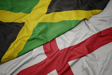 waving colorful flag of england and national flag of jamaica.