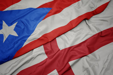 waving colorful flag of england and national flag of puerto rico.
